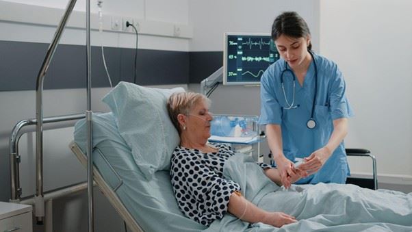 Medical assistant putting oximeter on patient